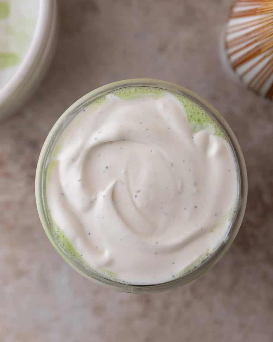 Creamy cold foam on top of a matcha latte