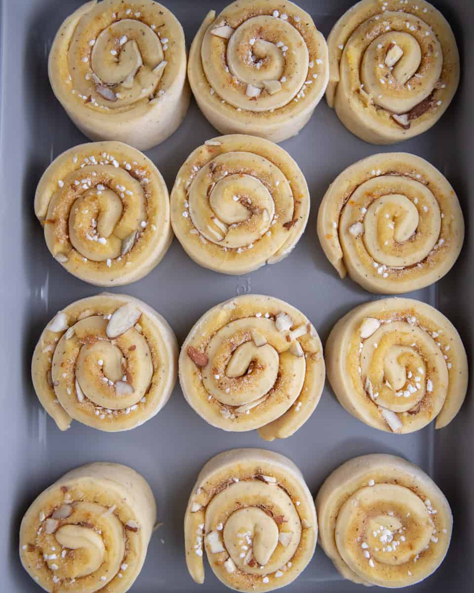 Shaped almond croissant cinnamon rolls rising in baking dish