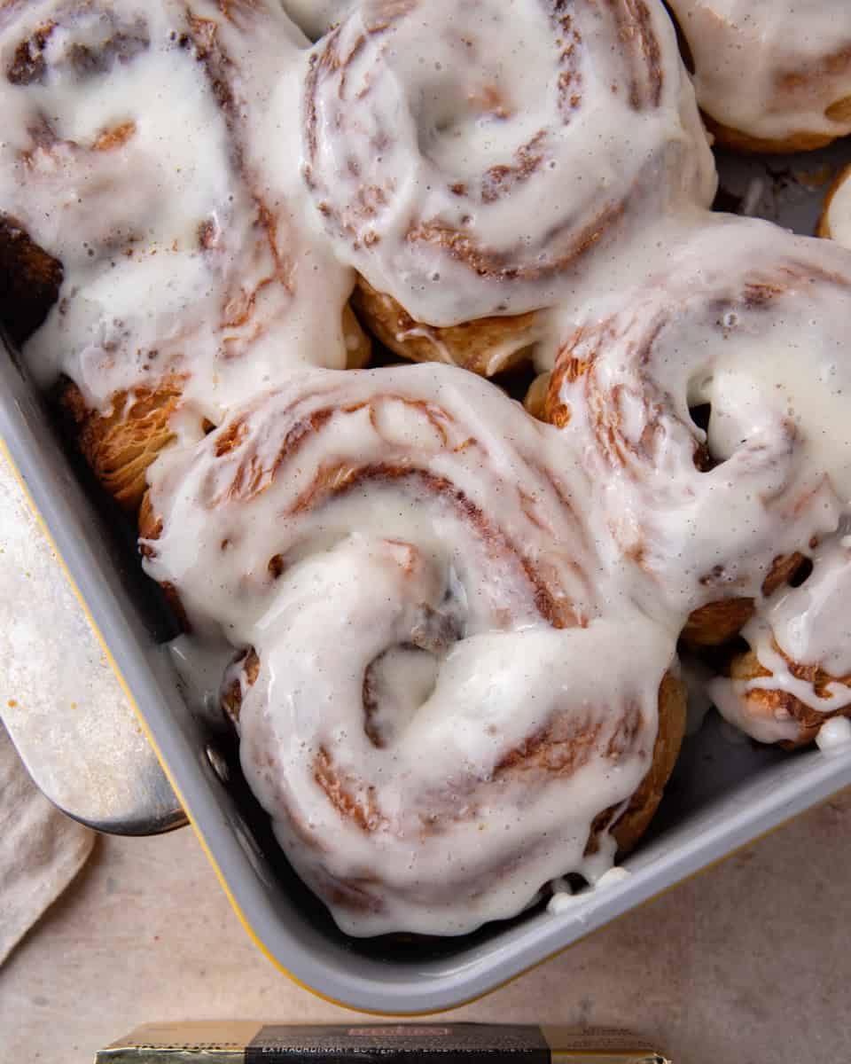 Pan of croissant cinnamon rolls topped with cream cheese glaze