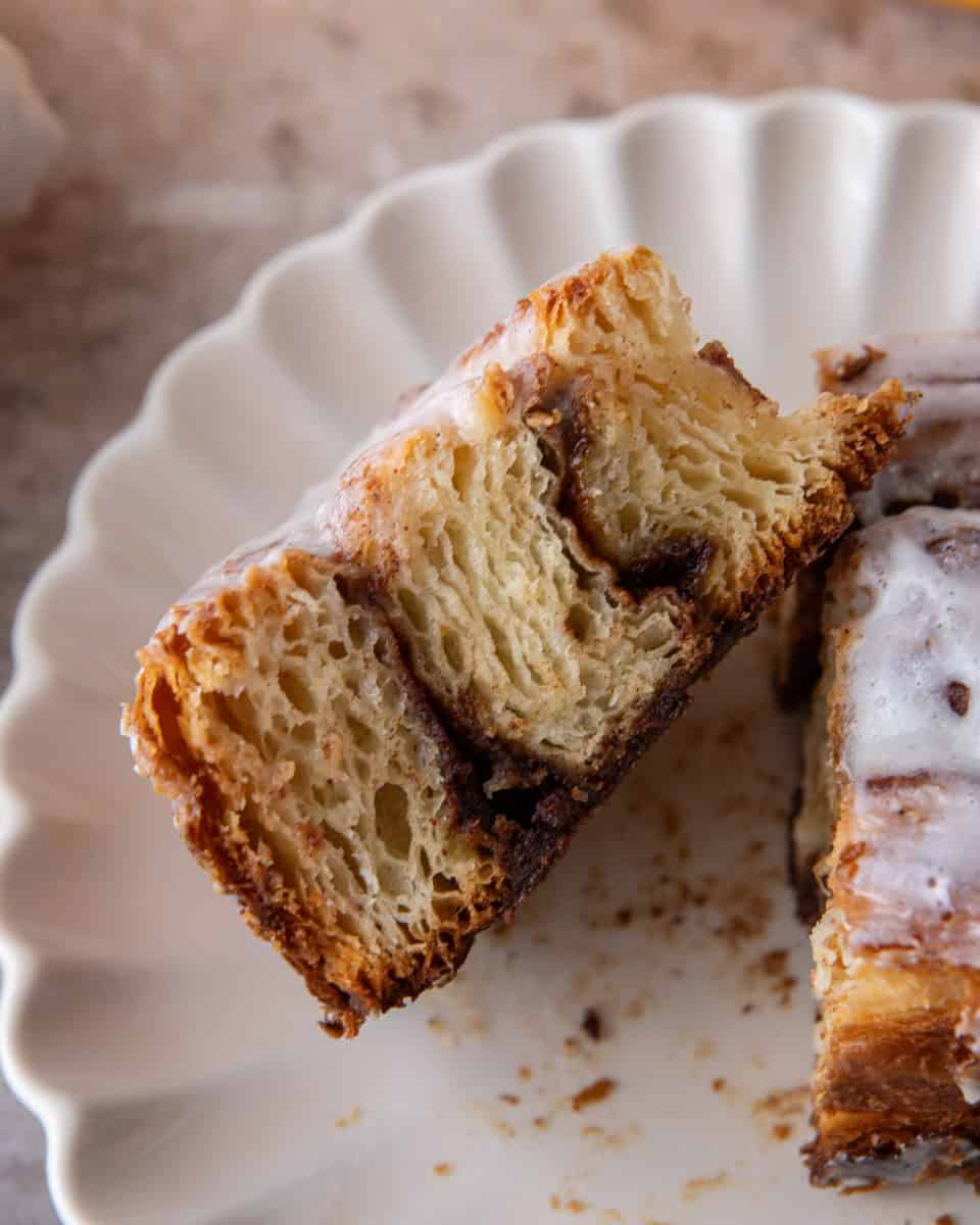 Croissant cinnamon roll cut in half showing flaky laminated layers