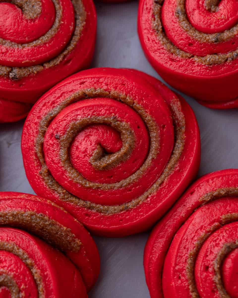 Close-up of shaped red velvet cinnamon rolls after proofing