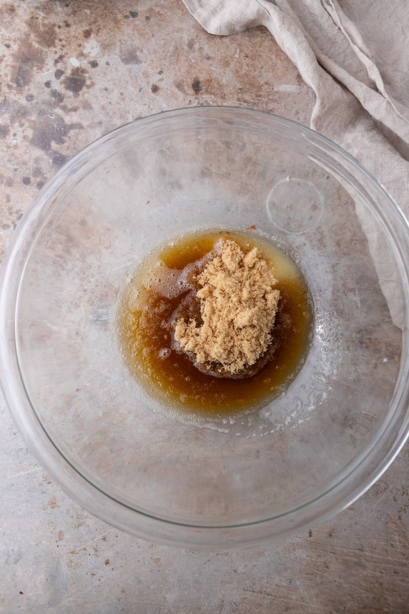 Cooled brown butter and light brown sugar in a glass mixing bowl before whisking together for skillet cookie dough