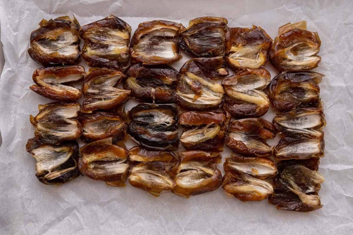 Medjool dates pressed flat on parchment paper for the base
