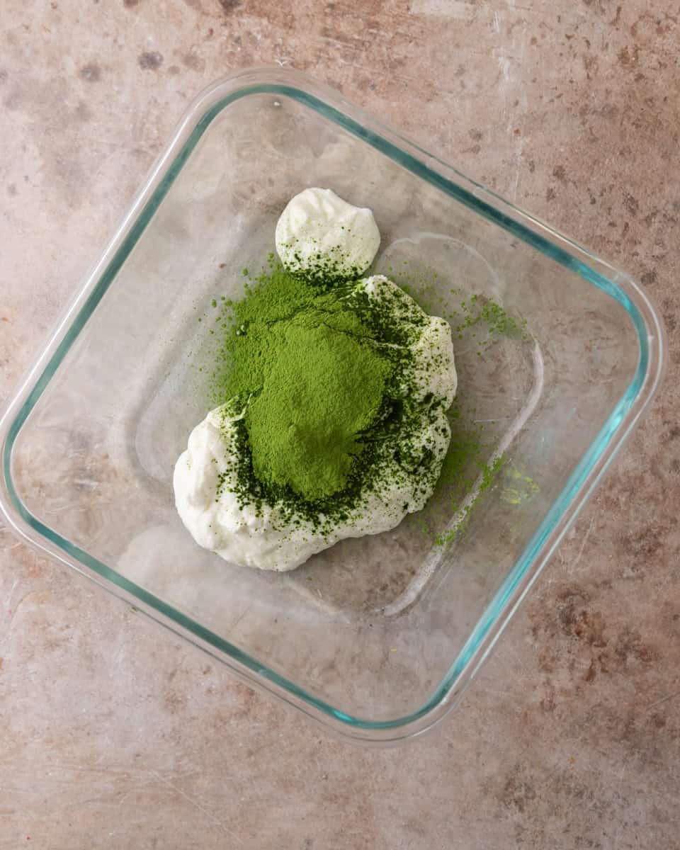 Matcha powder added to Greek yogurt in a bowl