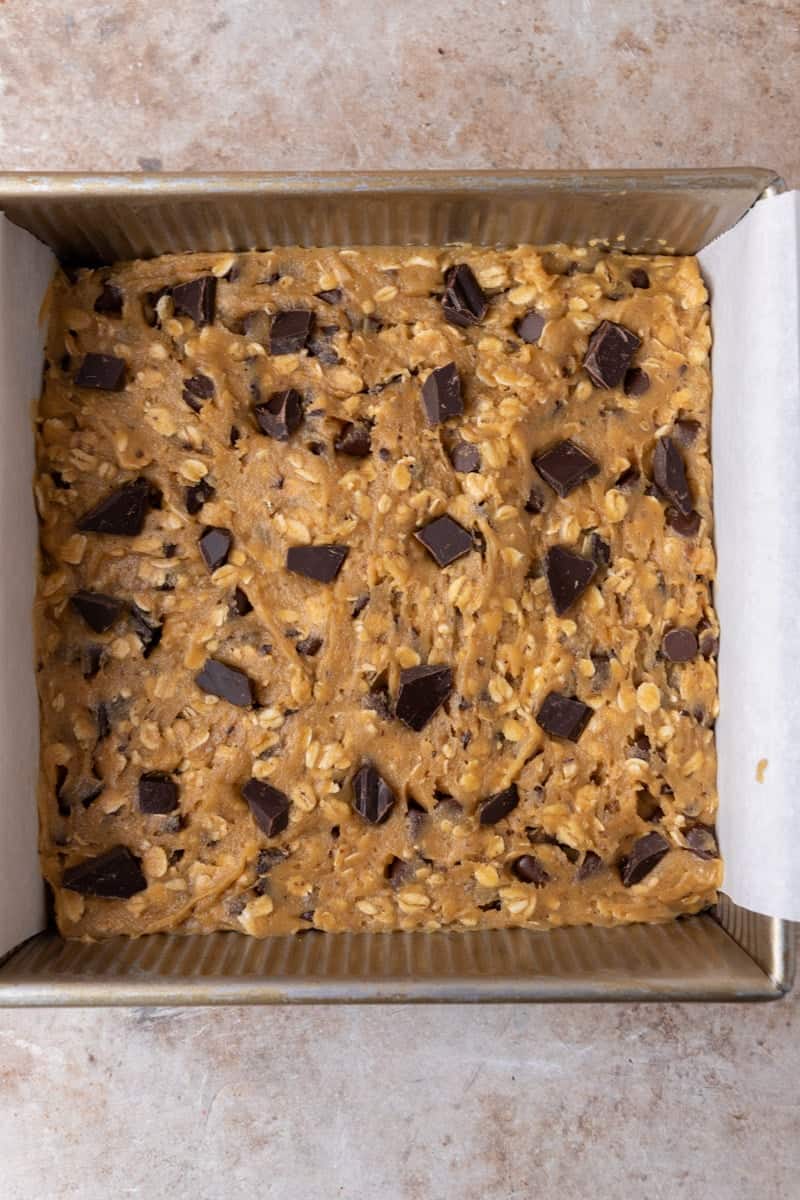 Close up of sliced chewy cookie bars with one tilted to show the gooey chocolate center and soft interior