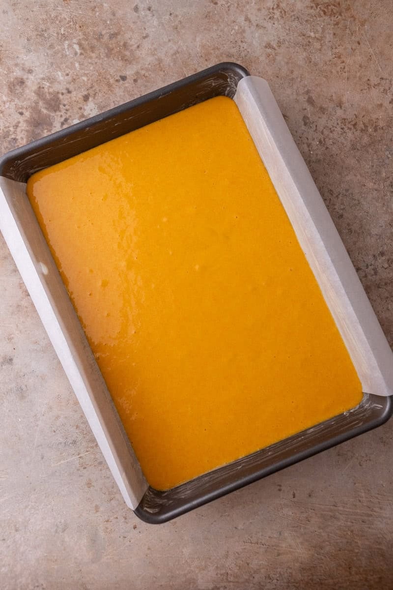 Unbaked Brazilian carrot cake batter poured into a parchment-lined 9x13 inch baking pan