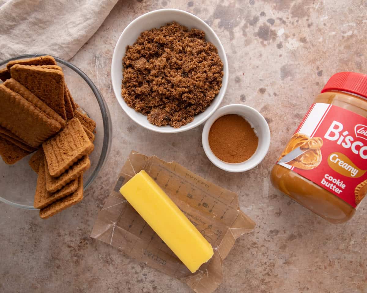 Cookie butter filling ingredients with Biscoff cookies, brown sugar, cinnamon, butter and a Lotus jar