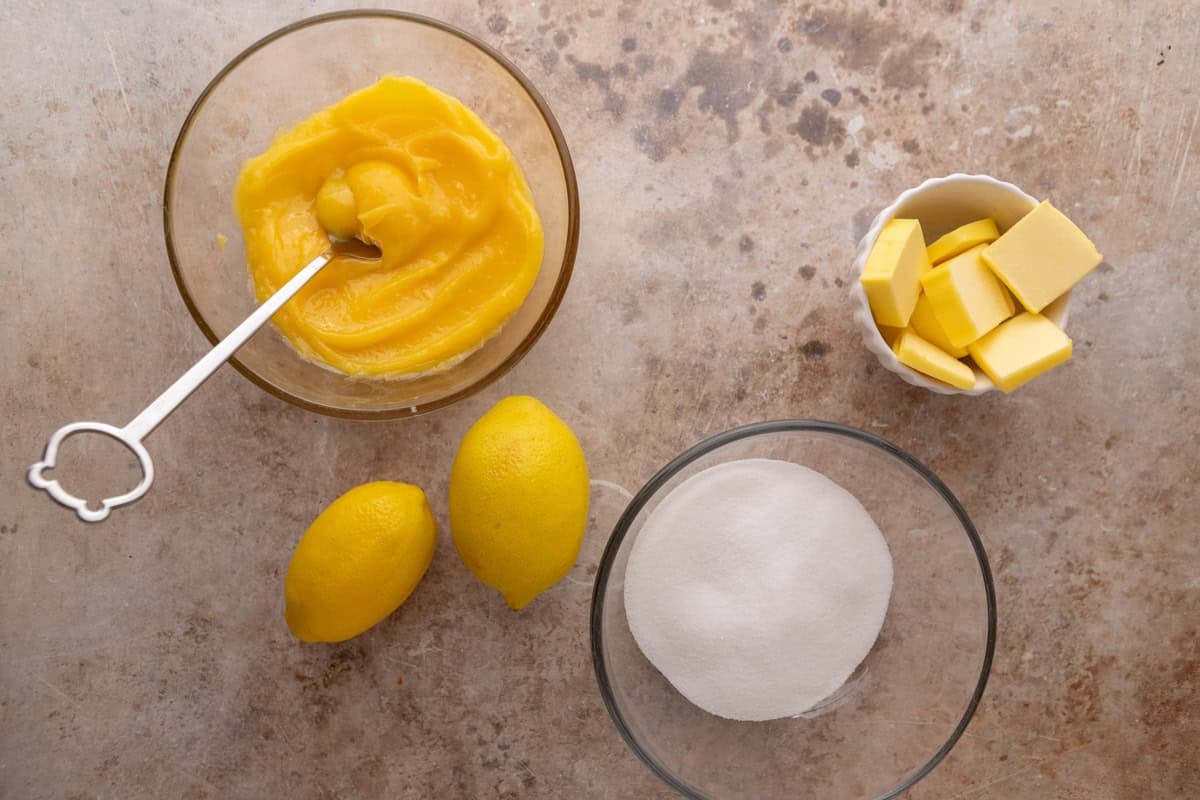 Lemon curd, butter, sugar and lemons for lemon roll filling