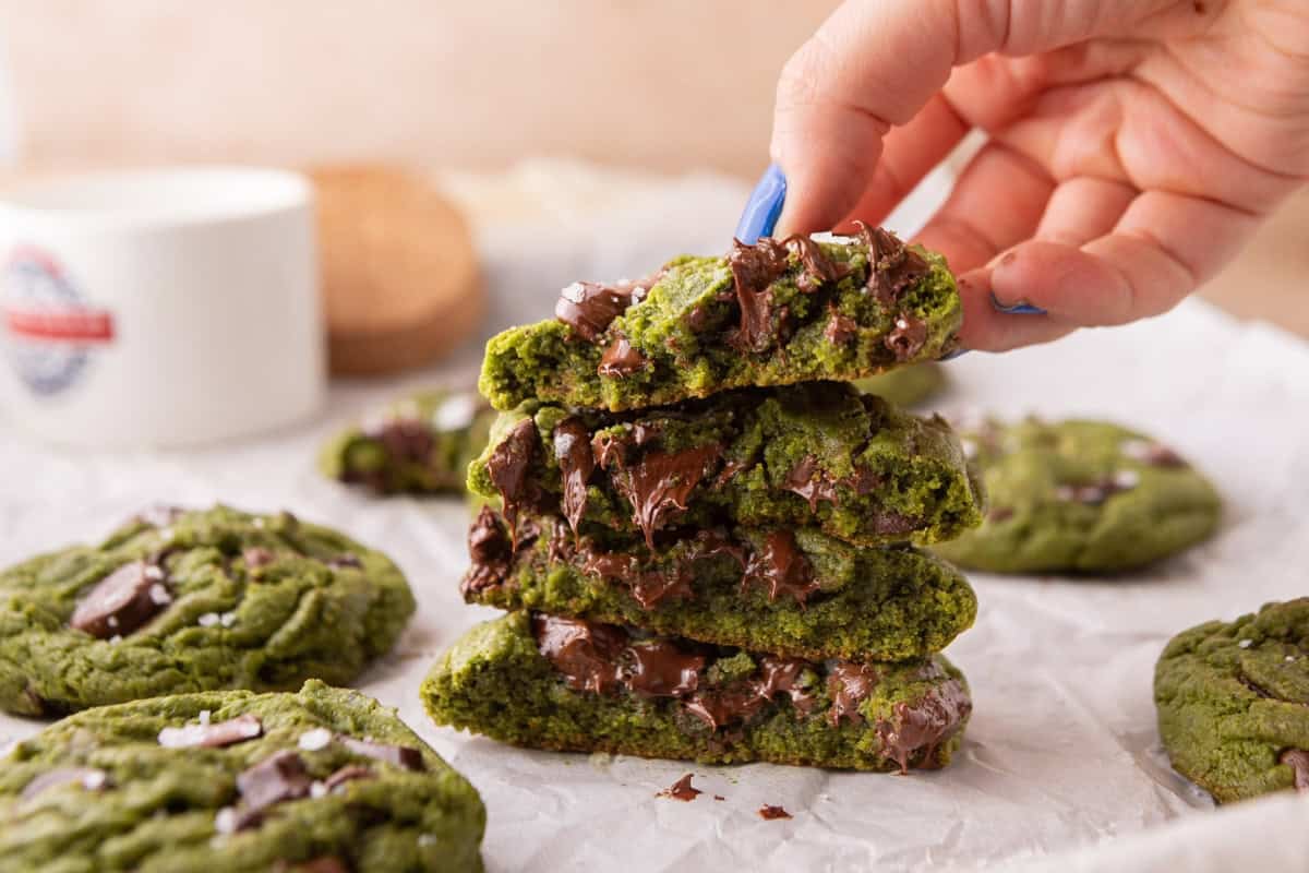 Stack of broken matcha chocolate chip cookies showing the soft chewy center and gooey melted chocolate