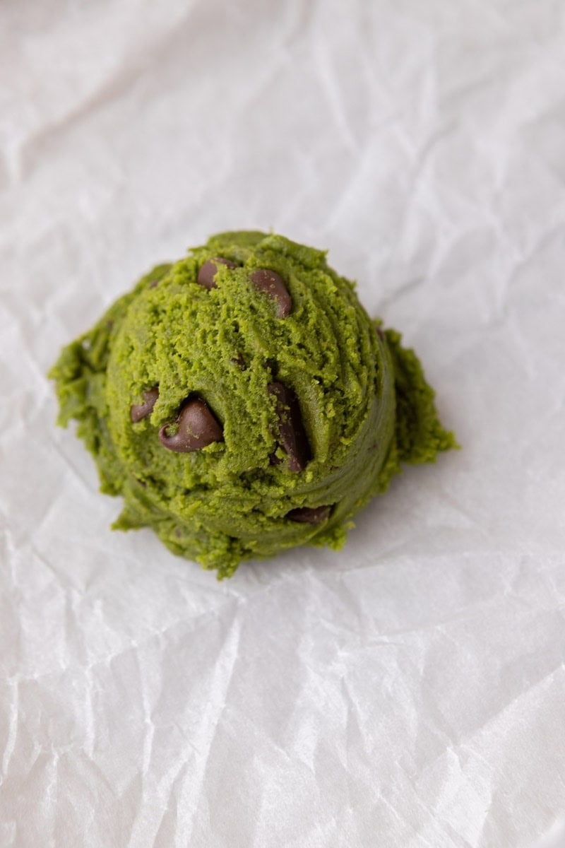 Finished matcha cookie dough with chocolate chips mixed throughout in a glass bowl