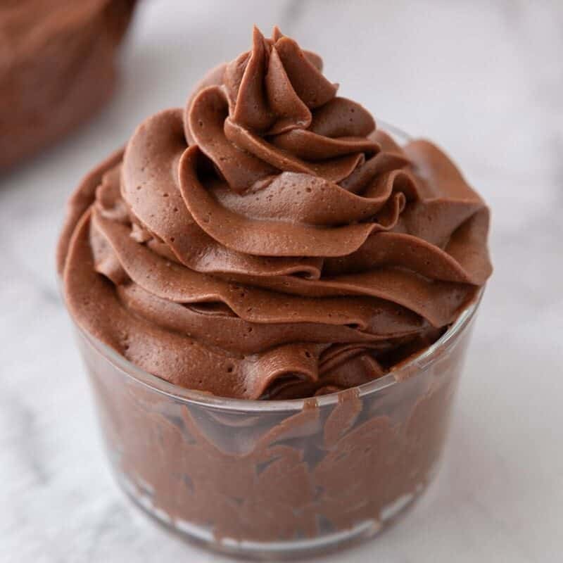 chocolate buttercream frosting piped into a swirl in a glass cup