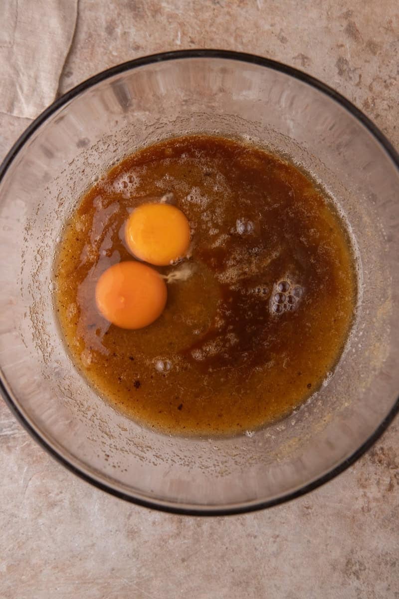 Eggs added to browned butter and sugar mixture in a glass bowl