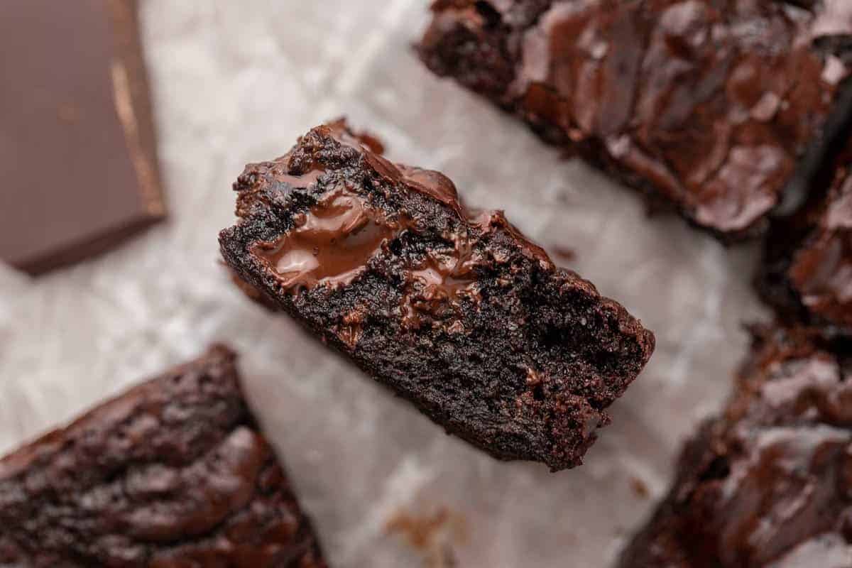 Small batch brownie with a melted chocolate chunk center on parchment paper showing the ultra fudgy interior texture