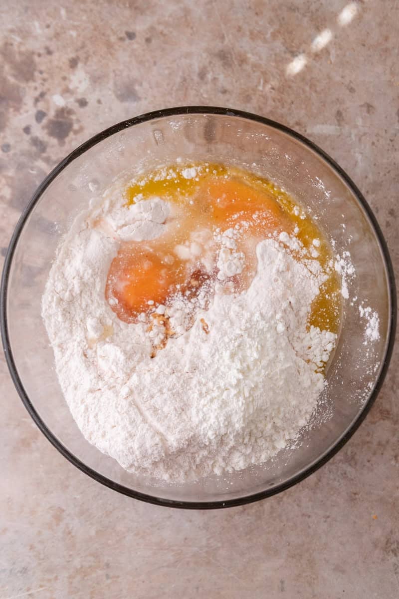 Strawberry cake mix, eggs, and melted butter combined in a glass mixing bowl before stirring