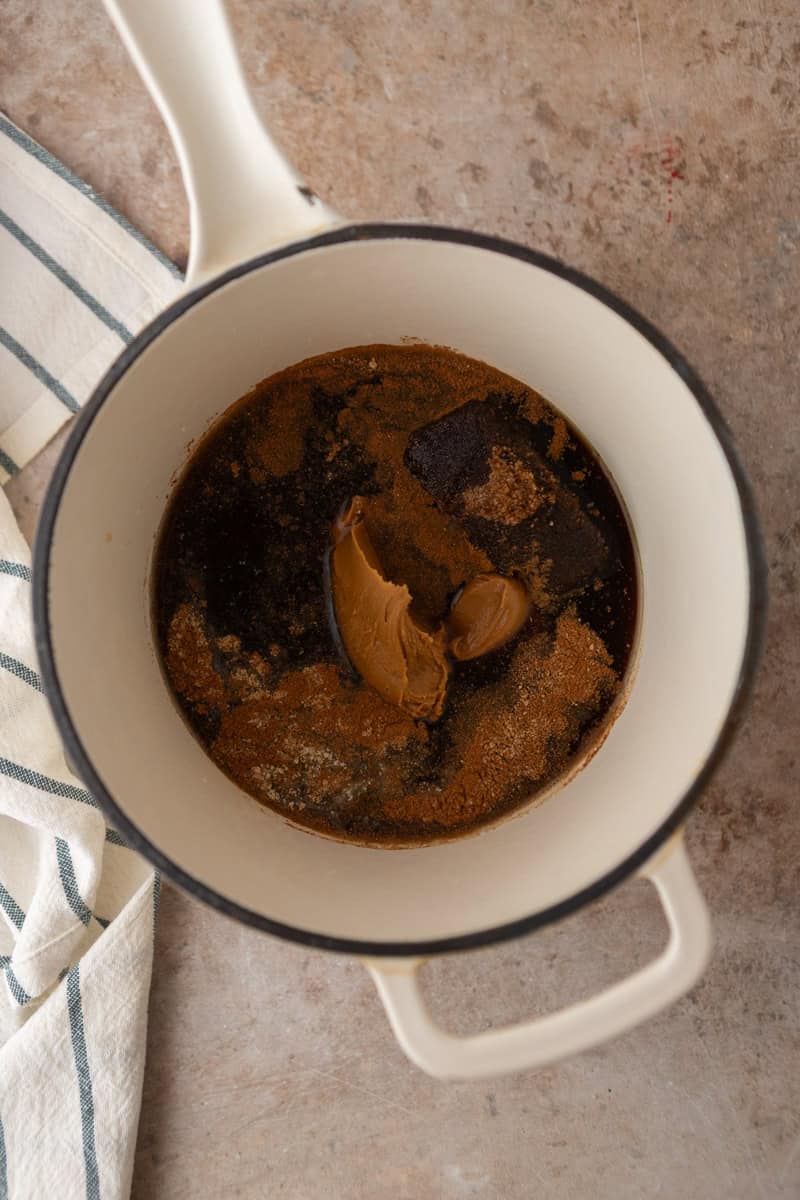 Dark brown sugar, Biscoff cookie butter, and spices added to a saucepan before cooking.