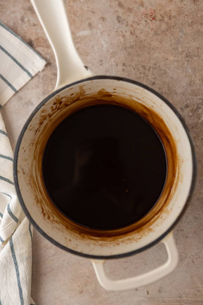 Coffee syrup after simmering in a saucepan, smooth and dark.