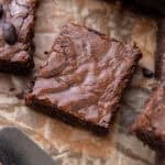 Close up of a single brownie square with shiny meringue-like crinkly top