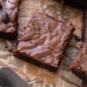 Close up of a single brownie square with shiny meringue-like crinkly top