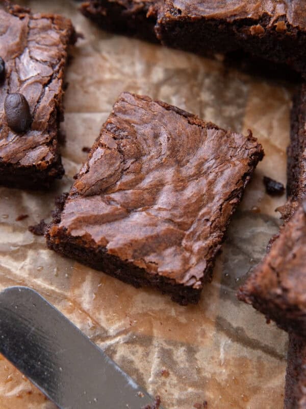Close up of a single brownie square with shiny meringue-like crinkly top