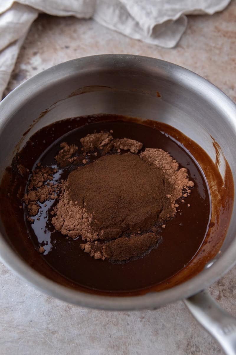 Melted chocolate mixture with cocoa powder and espresso powder added in a saucepan