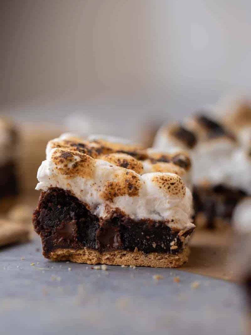 S'mores brownie bar showing the three layers of graham cracker crust base, fudgy chocolate brownie middle, and toasted marshmallows on top