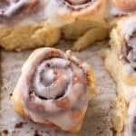 Single mini cinnamon roll with cream cheese glaze pulled from the pan showing soft texture