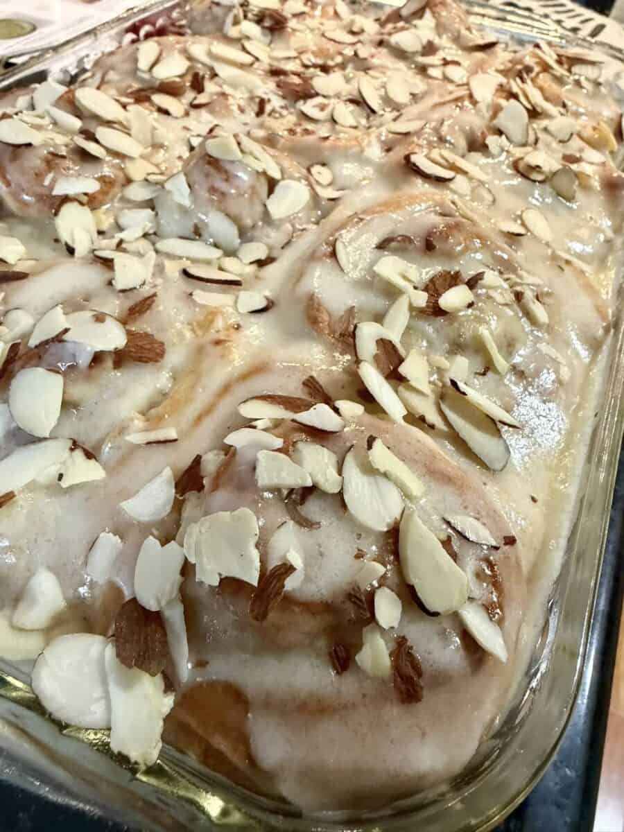 Glazed almond cinnamon rolls topped with sliced almonds, a past Loaf BakeClub featured recipe