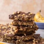 Stack of banana bread Christmas crack pieces on a plate with a banana in the background.