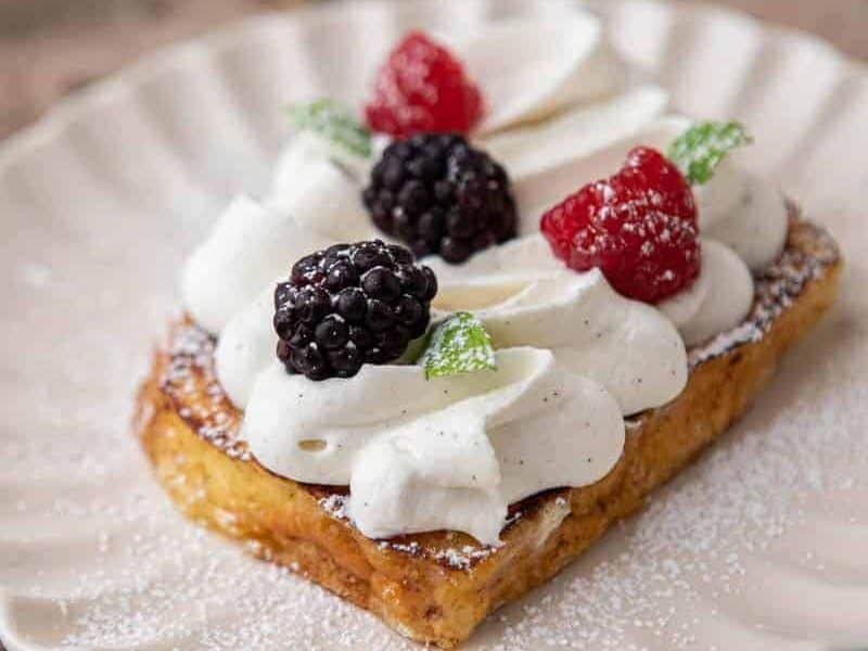 Brioche French toast with whipped cream and fresh berries on top