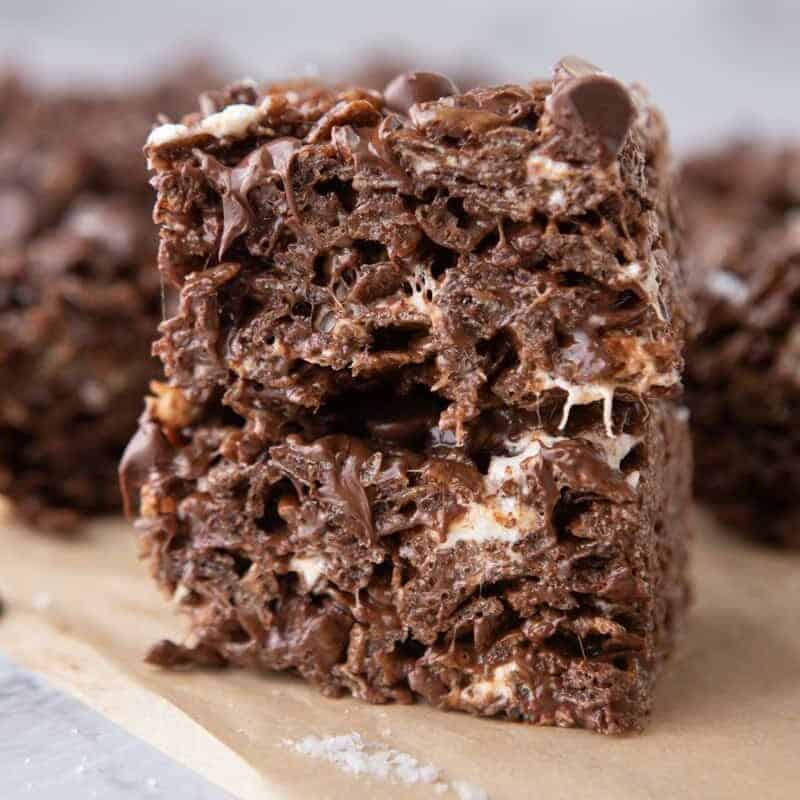 Two chocolate rice krispie treats stacked to show the chewy interior with melted chocolate and marshmallow pockets