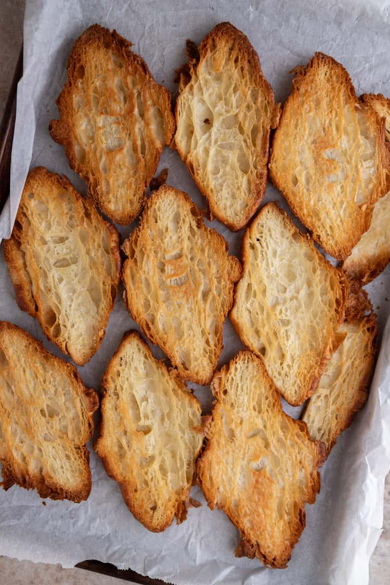 Pressed croissants baked deep golden and crisp on parchment, ready for toffee