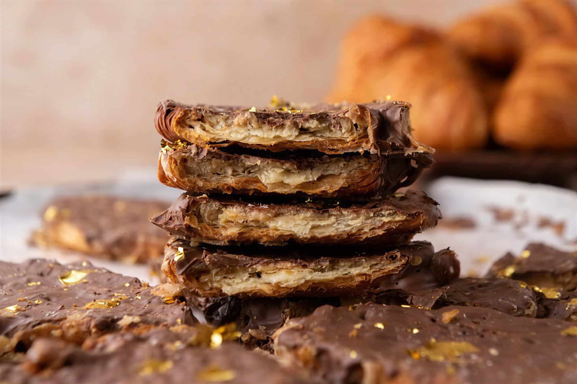 Stack of croissant Christmas crack pieces showing flaky croissant layers, brown sugar toffee and a dark chocolate top.