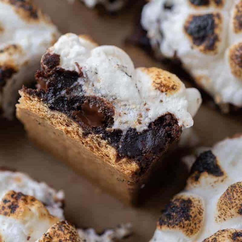 S'mores brownie batter spread over graham crackers in a parchment-lined pan