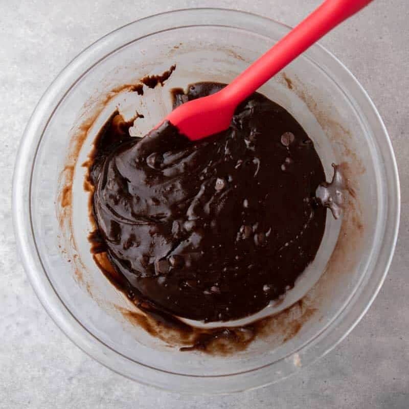 Thick brownie batter folded with chocolate chips in a bowl