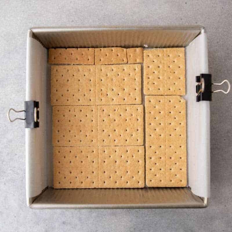 Graham cracker sheets lining the bottom of an 8x8 baking pan