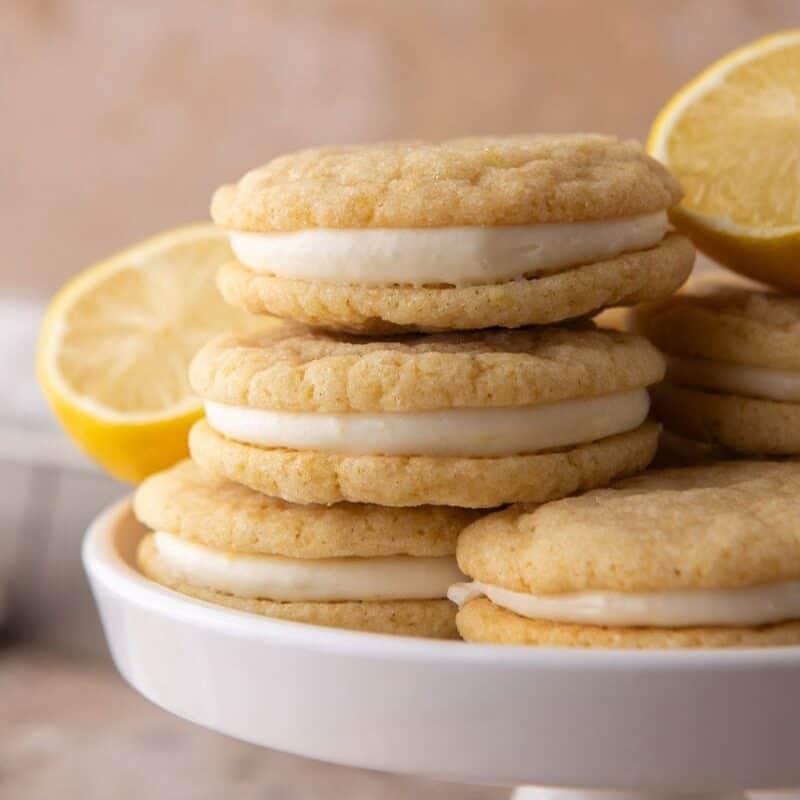 Freshly baked lemon sugar cookies cooling on a parchment-lined baking sheet.
