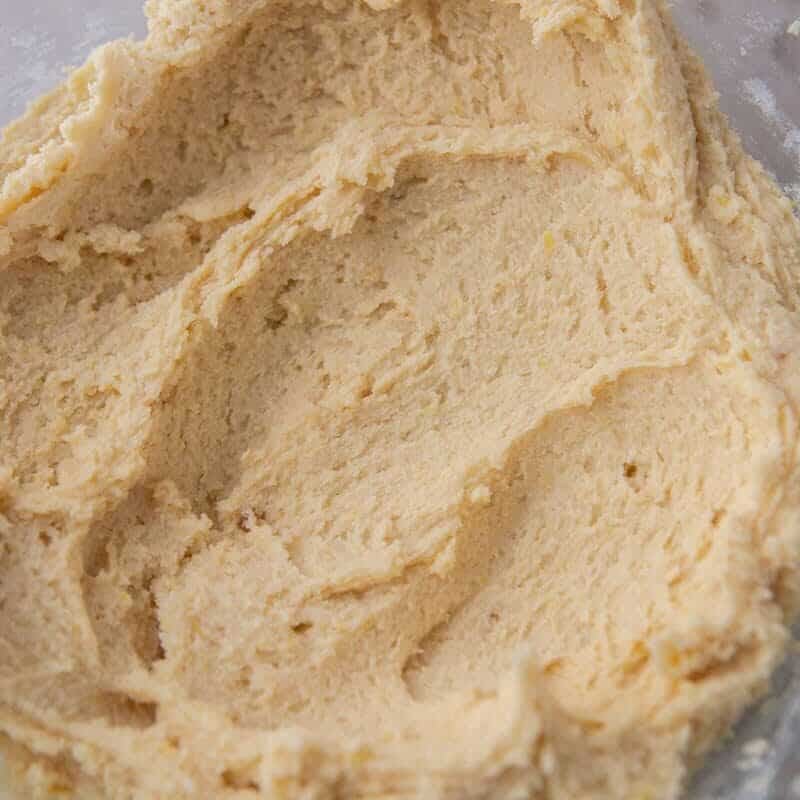 Soft, fluffy lemon cookie dough fully mixed in a glass bowl, ready to be scooped and chilled.