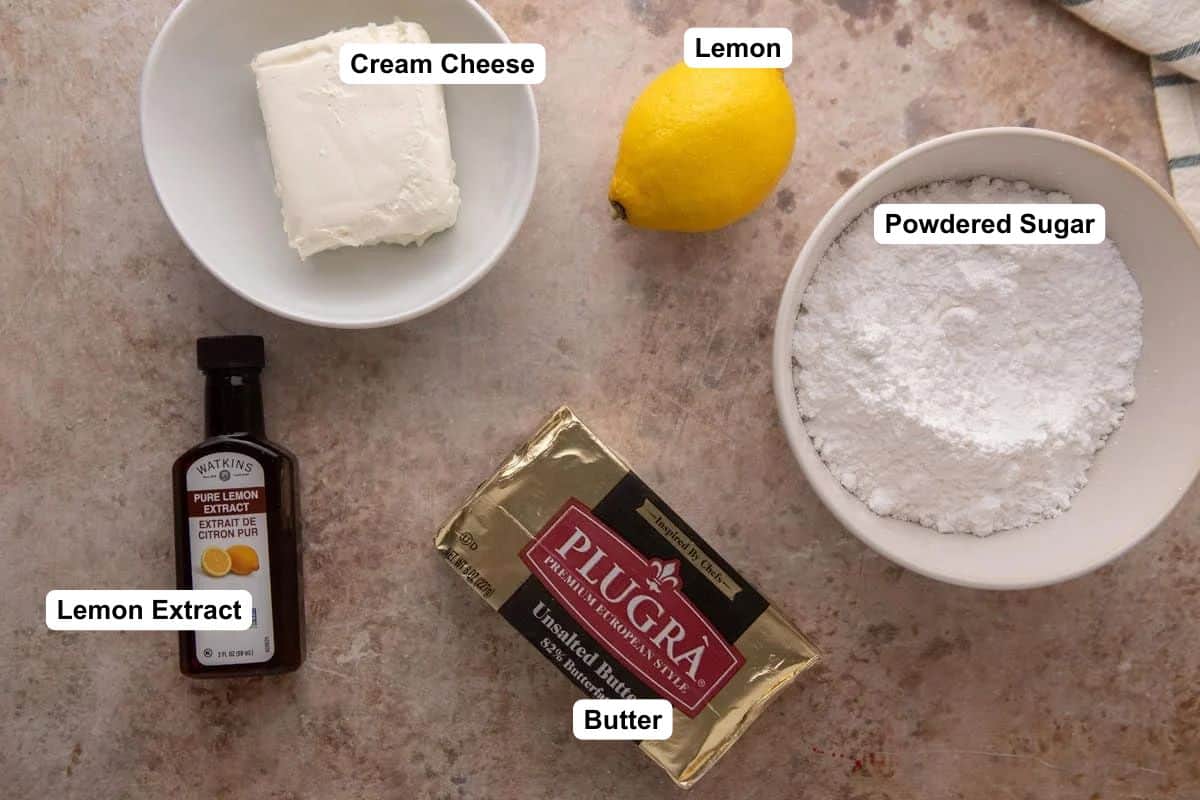 Cream cheese lemon frosting ingredients flat lay with Plugrà butter, cream cheese, powdered sugar, lemon, and lemon extract.