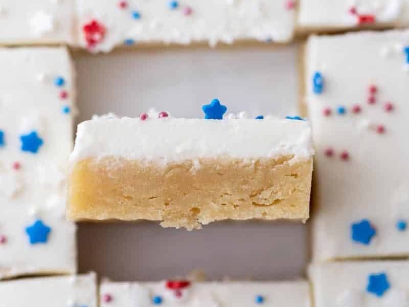 Sliced patriotic cookie bars cut into squares with vanilla buttercream frosting