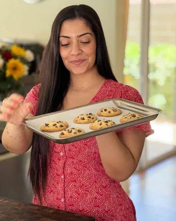 Chahinez from Lifestyle of a Foodie holding a tray of chocolate chip cookies for Loaf BakeClub