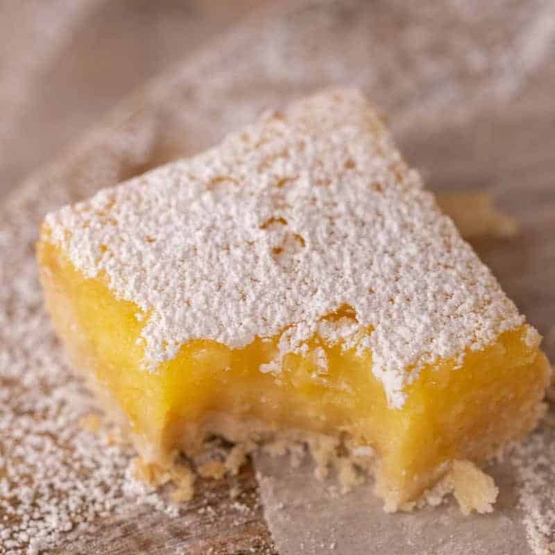 Classic lemon bar with buttery shortbread crust and tart lemon curd filling dusted with powdered sugar