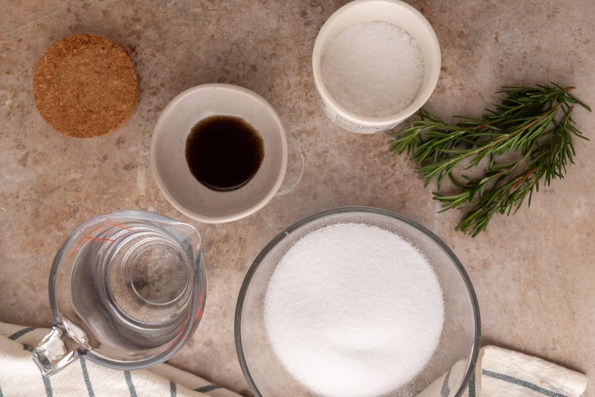 Ingredients for rosemary vanilla syrup including sugar, water, vanilla bean paste, fresh rosemary, and sea salt