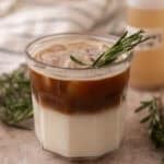 Layered rosemary latte with milk on the bottom and espresso poured over ice on top
