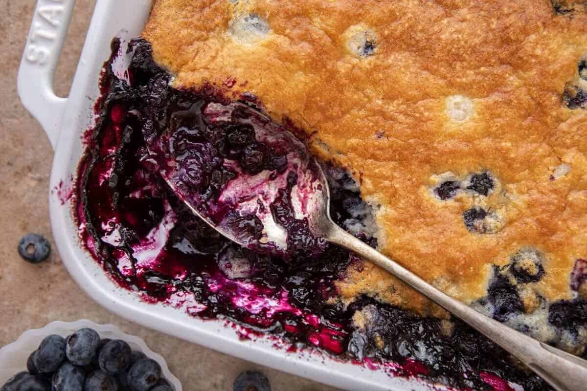 Quick and easy blueberry cobbler in a white baking dish with a golden topping