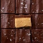 Overhead of buckeye fudge squares with one turned to show the peanut butter and chocolate layers