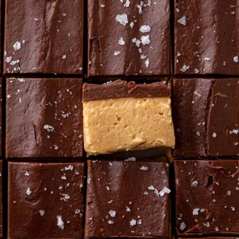 Overhead of buckeye fudge squares with one turned to show the peanut butter and chocolate layers
