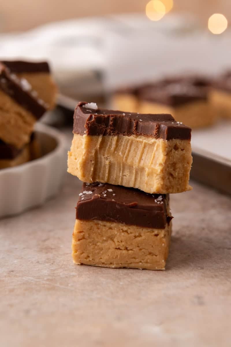 Close up of buckeye fudge showing the peanut butter layer and chocolate top with a bite taken