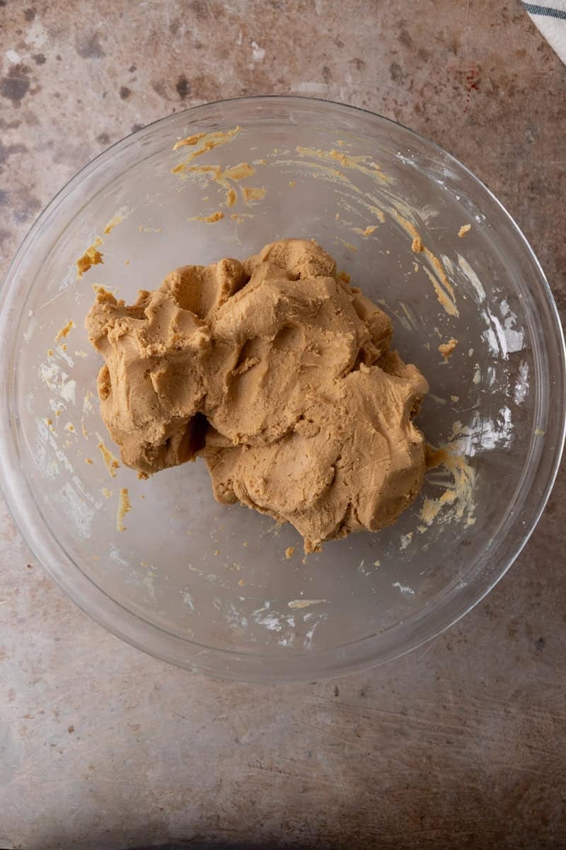 Thick peanut butter fudge dough formed into a ball in a glass bowl