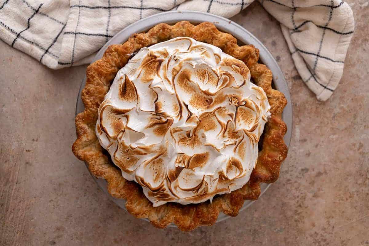 toasting Swiss meringue with kitchen torch on chocolate meringue pie