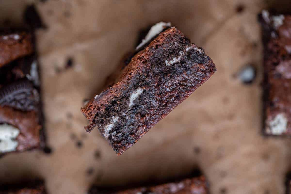 Close up of a fudgy Oreo brownie cut open to show the gooey interior and whole Oreo layer